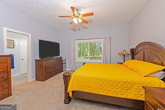 bedroom with light carpet, ceiling fan, a textured ceiling, and baseboards