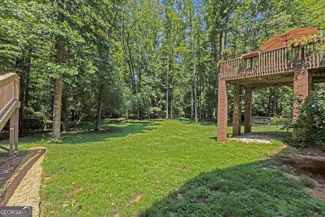 view of yard featuring a wooden deck and fence