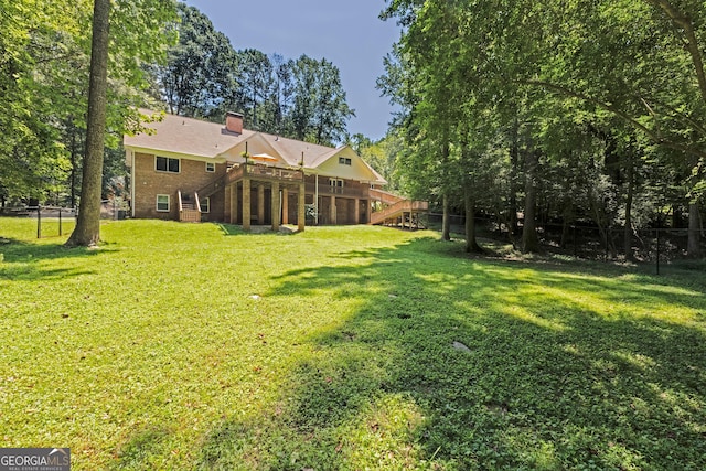 view of yard featuring fence, a deck, and stairs