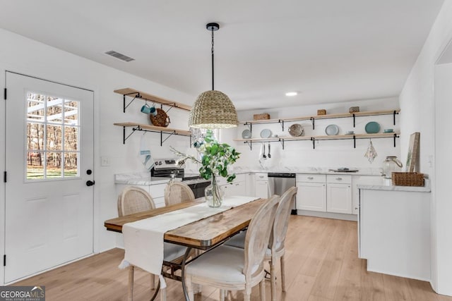 dining area featuring light wood-style floors and visible vents