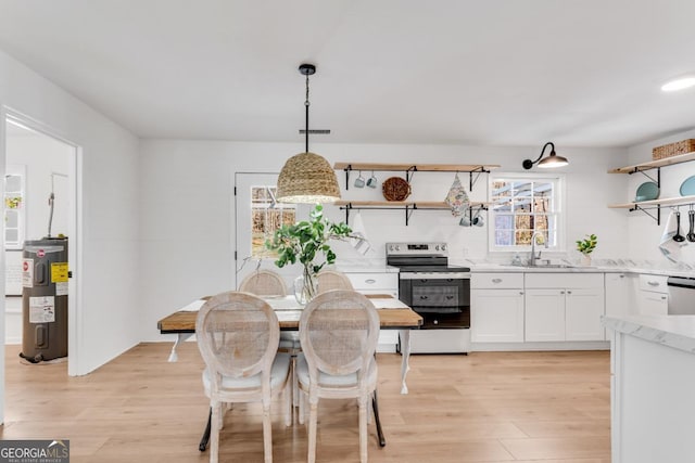 dining space with water heater, light wood finished floors, and visible vents