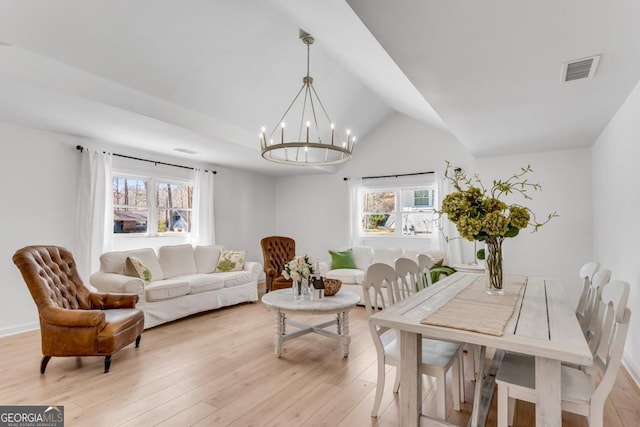 dining area featuring light wood-style flooring, visible vents, a wealth of natural light, and a chandelier