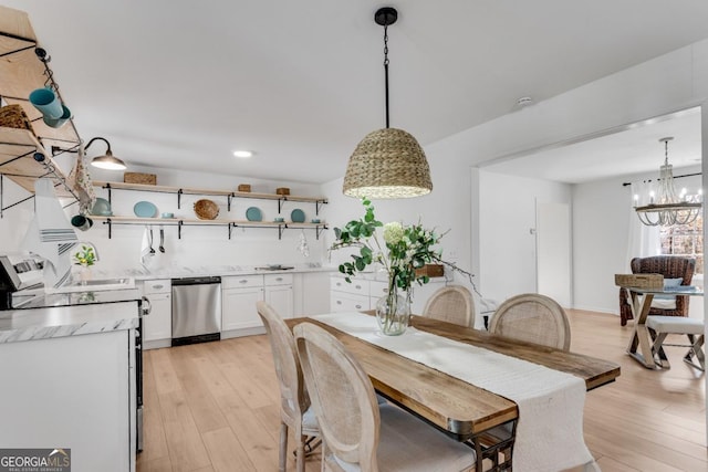 dining space with light wood-type flooring and an inviting chandelier