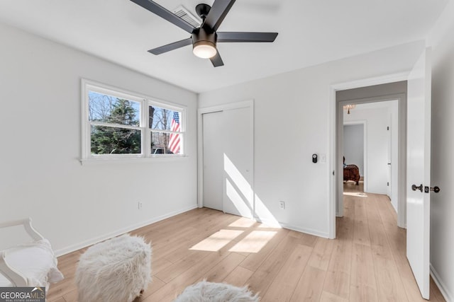 bedroom with light wood-type flooring, a closet, ceiling fan, and baseboards