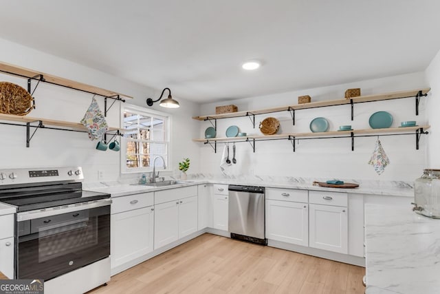 kitchen featuring white cabinets, light stone countertops, stainless steel appliances, open shelves, and a sink