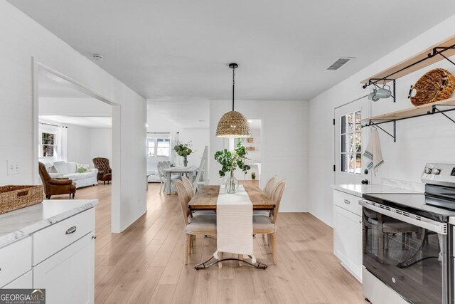 dining space featuring a wealth of natural light, light wood finished floors, and visible vents