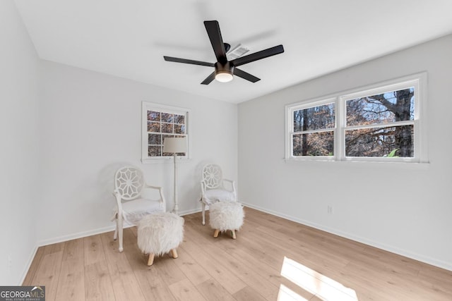 sitting room with light wood-style floors, baseboards, and a ceiling fan