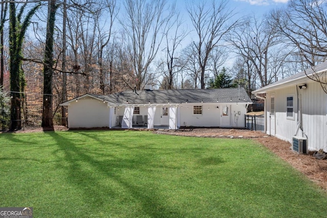 rear view of house featuring a lawn and fence