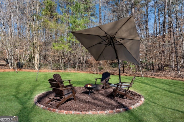 view of yard featuring an outdoor fire pit and fence