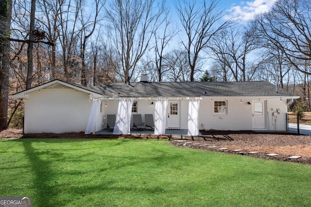 single story home featuring brick siding, roof with shingles, a chimney, a patio area, and a front lawn