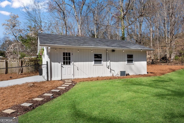 view of outdoor structure with central AC unit, an outdoor structure, and fence