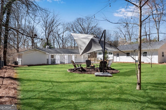 view of yard with an outdoor fire pit and fence