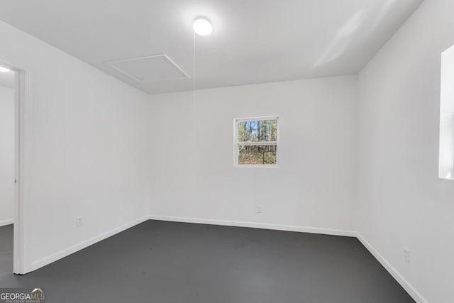 unfurnished room featuring finished concrete flooring and baseboards