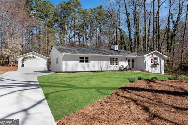 ranch-style home with a chimney, an outdoor structure, a detached garage, and a front lawn