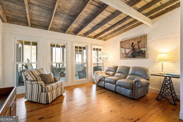 living area featuring lofted ceiling with beams, wooden ceiling, wooden walls, and hardwood / wood-style flooring