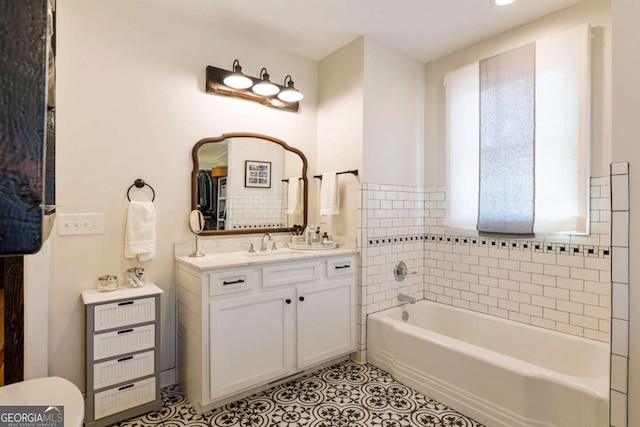 full bathroom with a bathtub, vanity, and tile patterned floors