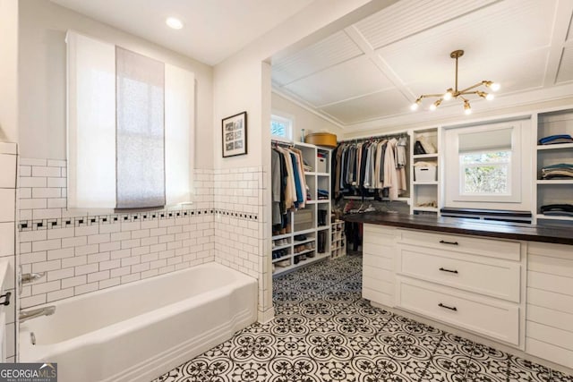 spacious closet featuring light tile patterned flooring and a notable chandelier