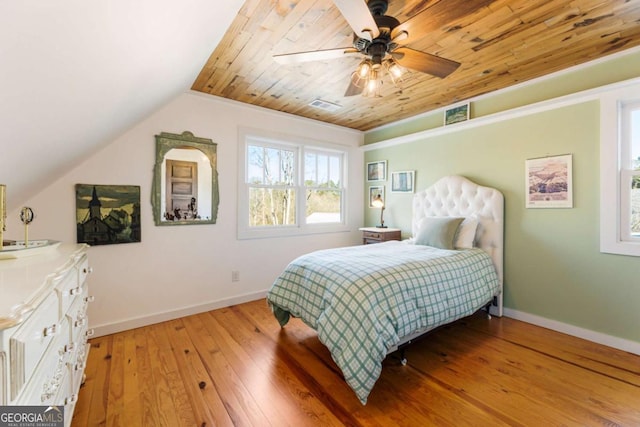 bedroom with vaulted ceiling, visible vents, light wood-style flooring, and baseboards