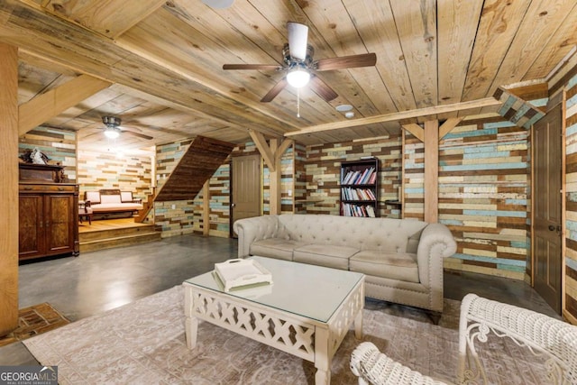 living area with a ceiling fan, wooden ceiling, concrete floors, and wooden walls