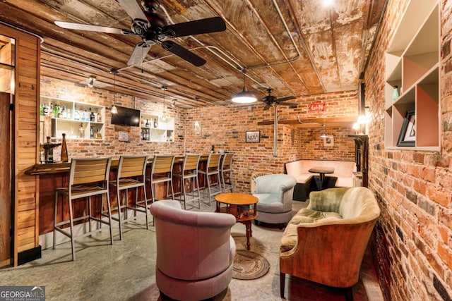 interior space featuring wood ceiling, brick wall, a community bar, and a ceiling fan