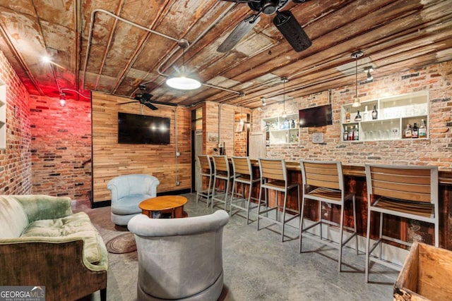 living area with ceiling fan, brick wall, a dry bar, and wood ceiling