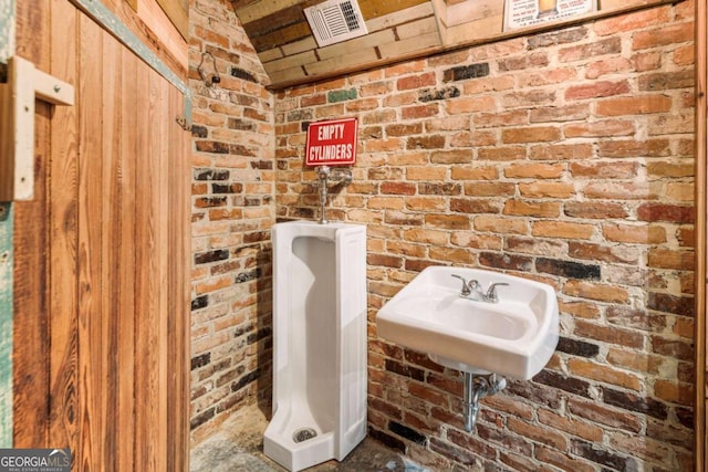 full bathroom with visible vents, a sink, and brick wall