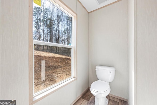 bathroom featuring toilet, visible vents, baseboards, and wood finished floors