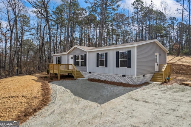 manufactured / mobile home featuring a deck, driveway, and crawl space