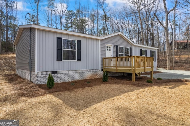 manufactured / mobile home with crawl space, driveway, and a wooden deck