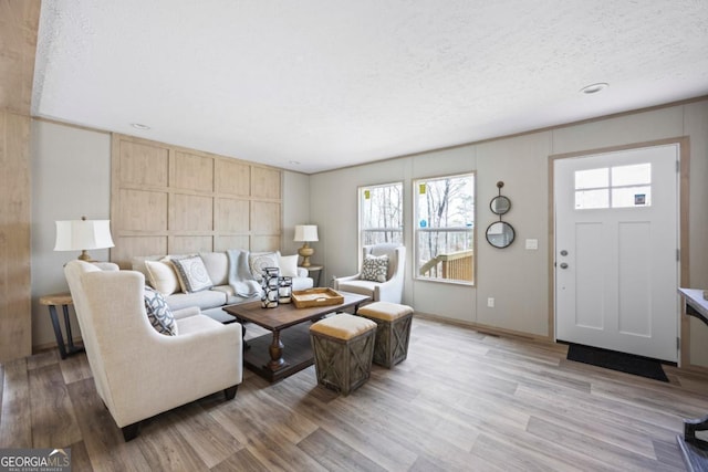 living area featuring light wood-style flooring and a textured ceiling