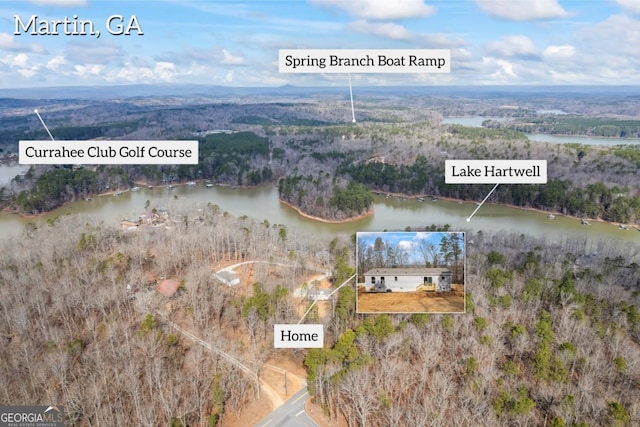 birds eye view of property featuring a water view and a wooded view