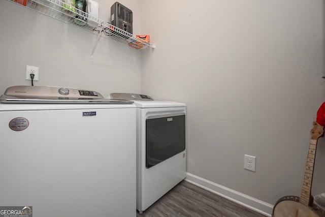 laundry area featuring laundry area, dark wood-style flooring, washing machine and dryer, and baseboards