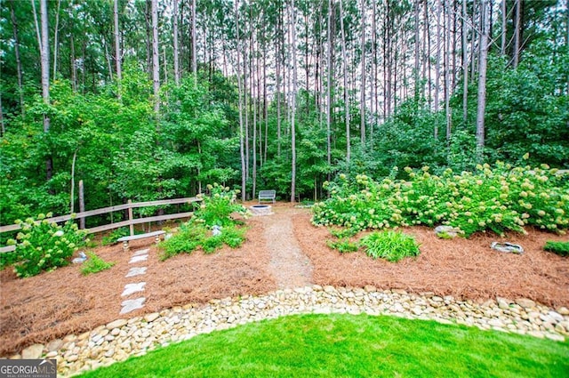 view of yard featuring a garden and a forest view