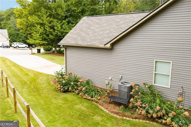 view of property exterior with cooling unit, a yard, and fence