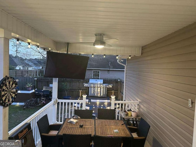 deck featuring outdoor dining area, ceiling fan, grilling area, and fence