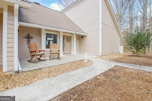 doorway to property with a shingled roof