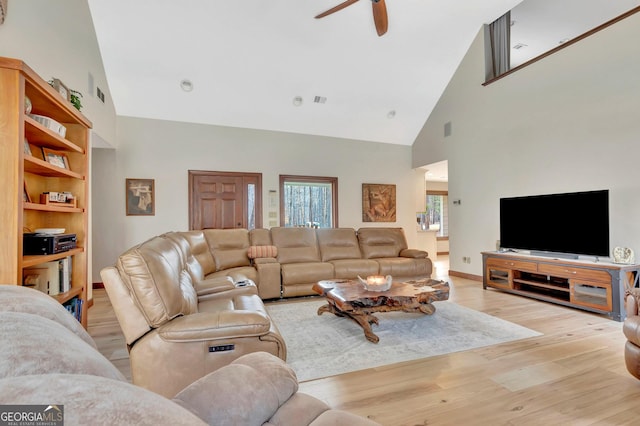 living room with ceiling fan, high vaulted ceiling, light wood finished floors, and baseboards