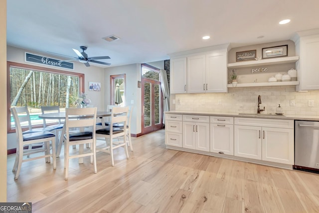 kitchen with visible vents, decorative backsplash, dishwasher, light wood-style floors, and a sink