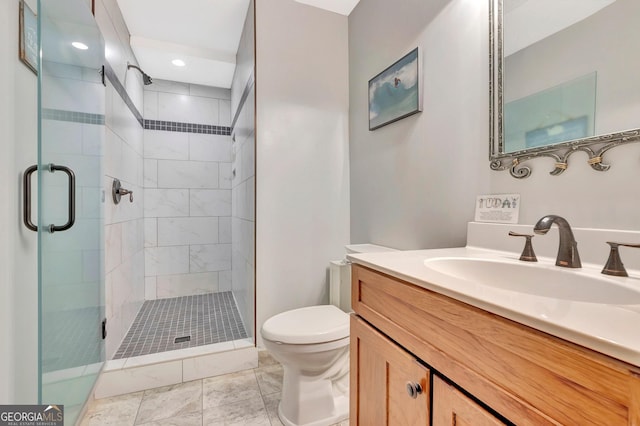 bathroom with vanity, a shower stall, and toilet