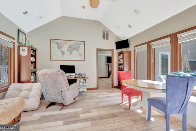 living room featuring high vaulted ceiling, baseboards, visible vents, and light wood finished floors