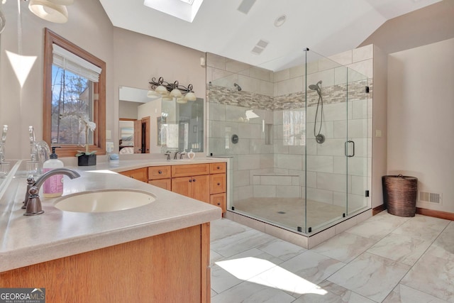 full bathroom featuring visible vents, vanity, marble finish floor, a shower stall, and lofted ceiling with skylight