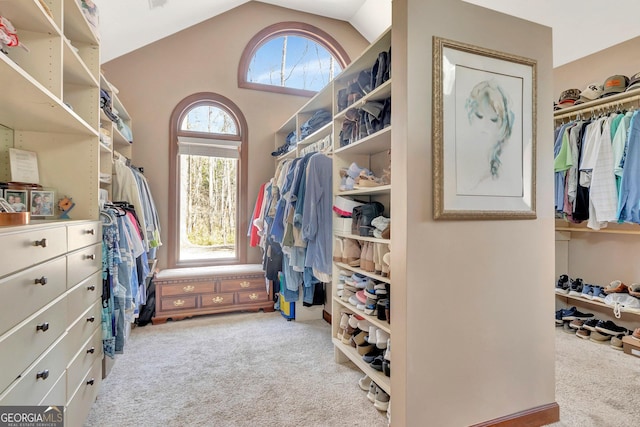 walk in closet featuring carpet flooring and vaulted ceiling