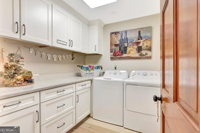 clothes washing area featuring cabinet space, light wood finished floors, and washer and dryer