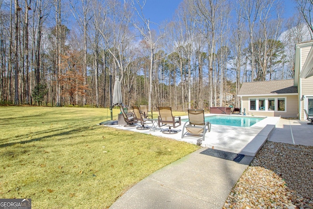 outdoor pool featuring a lawn and a patio