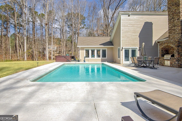 pool featuring a patio area, a grill, a hot tub, and an outdoor kitchen