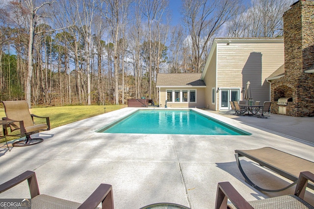 pool featuring french doors, a patio area, grilling area, and an outdoor kitchen