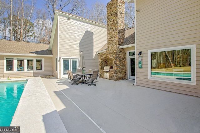 view of patio / terrace featuring exterior kitchen, outdoor dining space, an outdoor pool, and area for grilling