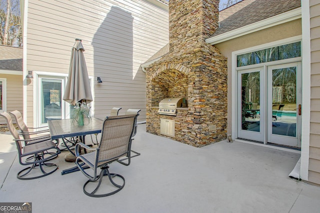 view of patio featuring grilling area, outdoor dining area, exterior kitchen, and french doors