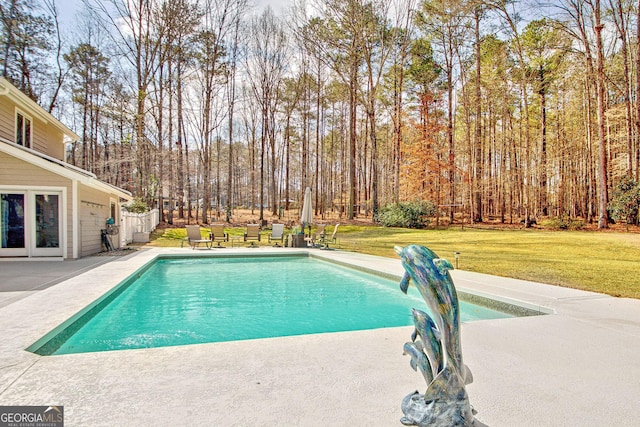 pool featuring a lawn and a patio area