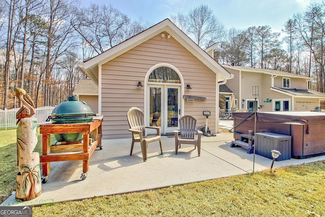 back of property with a patio area, a hot tub, and fence